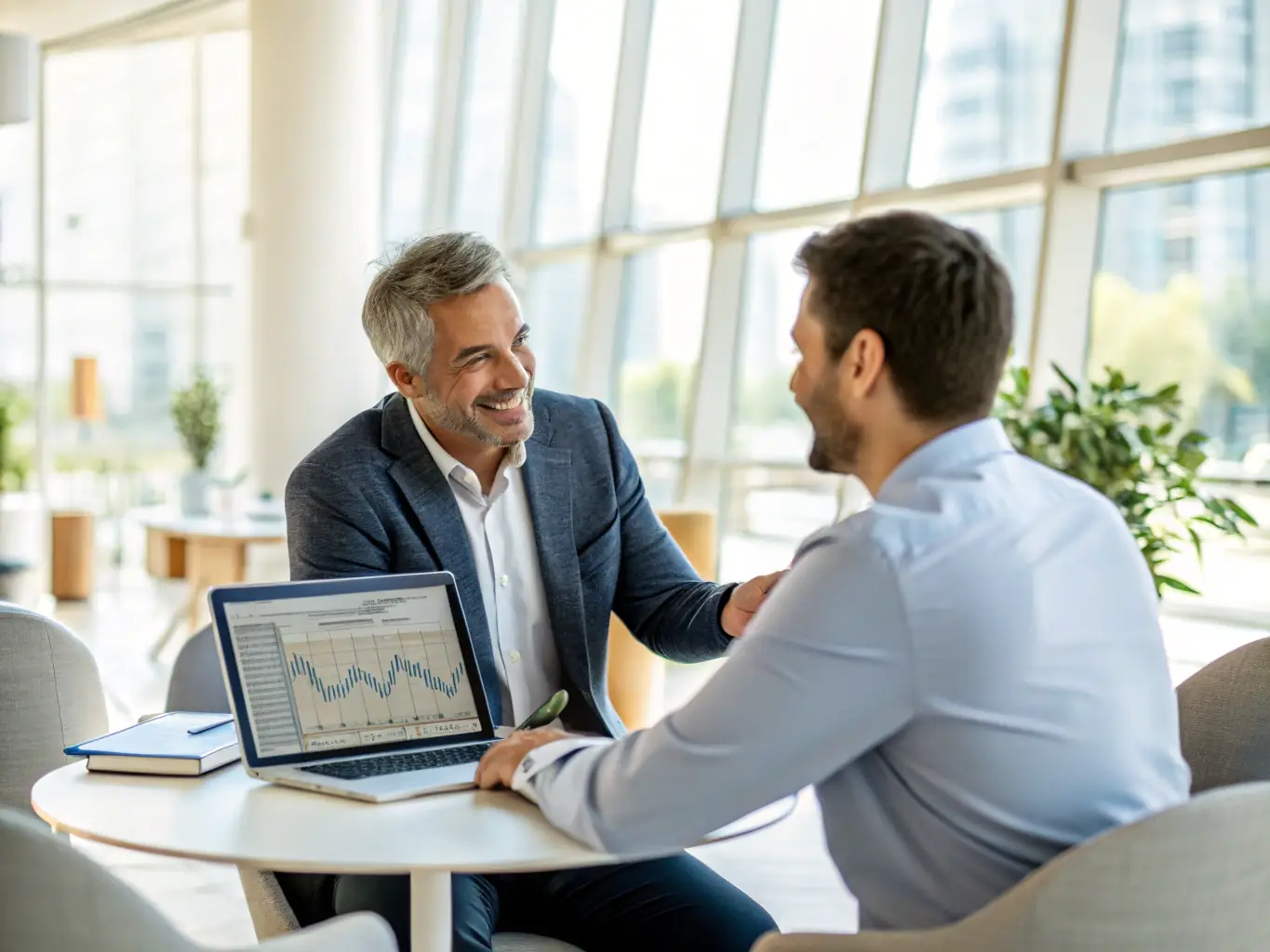 A professional coach is guiding a client through an investment platform interface on a laptop, showcasing real-time data and analytics.
